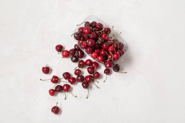 Hafif arka planda taze kirazlı plastik konteynır