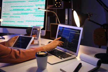 Geceleri ofiste cihazlarla çalışan kadın programcı, yakın plan