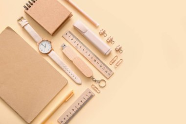 Bej arka planda farklı okul kırtasiyesi, not defteri ve kol saati