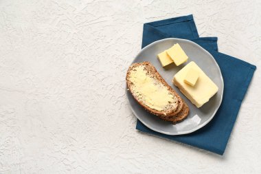 Plate with fresh butter and tasty toast on white background