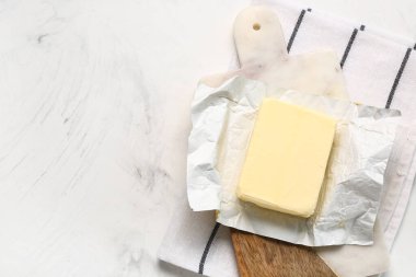 Beyaz arkaplanda taze tereyağı olan tahta