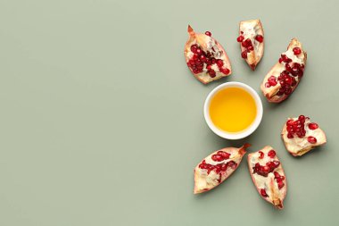 Rosh Hashanah kutlaması (Yahudi Yeni Yılı) için gri arka planda bir kase bal ve nar.