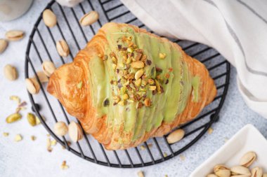 Beyaz arka planda lezzetli kruvasan ve fıstıklı şebeke, yakın plan.