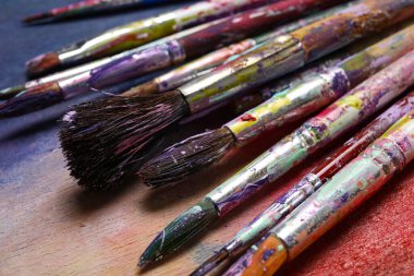 Renkli arka planda kirli boya fırçaları