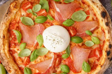 Gri arka planda Burrata peynirli lezzetli pizza.