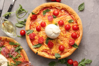 Gri arka planda Burrata peynirli lezzetli pizzalar.