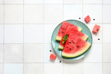 Açık fayanslı olgun karpuz parçalarıyla kaplı bir tabak.