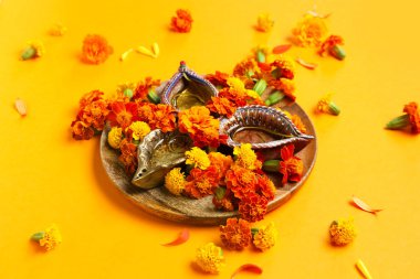 Turuncu arka planda kadife çiçekli Diya lambası. Divaly kutlaması