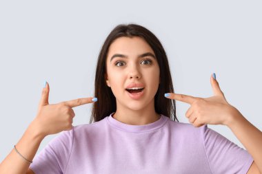 Genç bir kadın arka planda dişlerini gösteriyor, yakın plan.