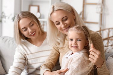 Annesi ve büyükannesiyle birlikte şirin küçük bir kız, yakın çekim.