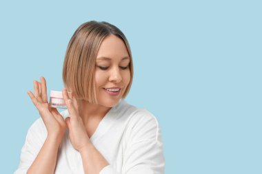 Olgun bir kadın elinde krem kavanozu tutuyor.