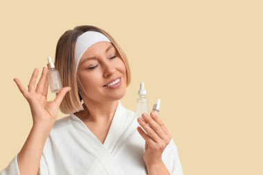 Renkli arka planda gerekli yağ şişeleriyle güzel olgun bir kadın.