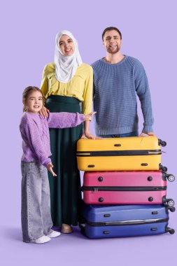 Leylak arkaplanlı bavulları olan güzel Müslüman bir aile. Seyahat kavramı
