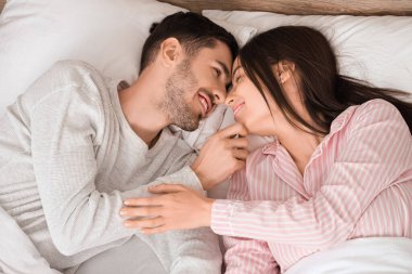 Genç çift yatakta yatıyor.