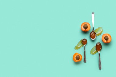 Yeşil arka planda tatlı kayısı reçelli metal kaşıklar