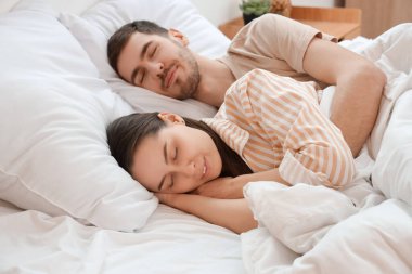 Yatakta uyuyan sevimli genç çift.