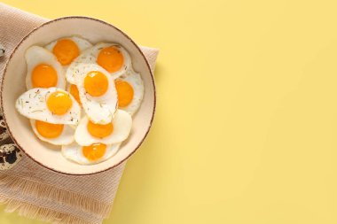 Sarı arka planda kızarmış bıldırcın yumurtalı kase.