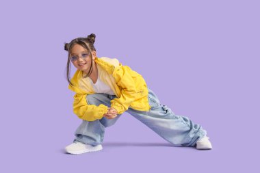 Eflatun arka planda yetişkin kıyafetleri içinde havalı bir Asyalı kız.