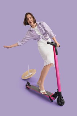 Motosikletli genç bir kadın leylak arka planına düşüyor.