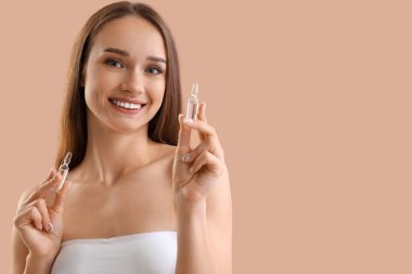 Bej arka planda ampule sahip güzel bir genç kadın, yakın plan.