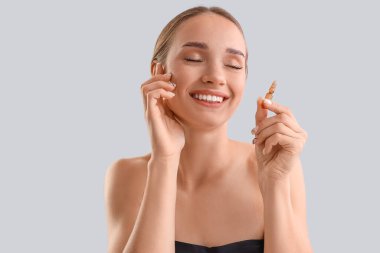 Işık arka planında ampulü olan mutlu genç kadın, yakın plan.