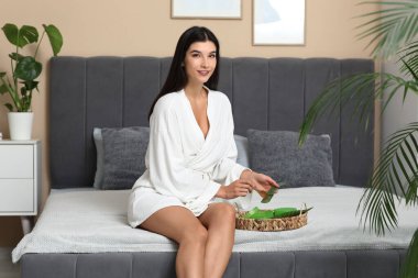 Güzel genç bir kadın evde aloe vera jeli yapıyor.