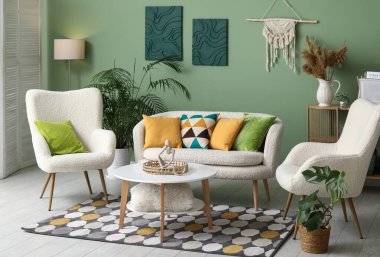 Beyaz kanepesi, koltuğu ve kahve masası olan şık bir oturma odası.