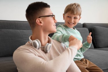 Çalışan babasıyla evde yumruk tokuşturan küçük bir çocuk.
