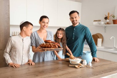 Mutfakta challah ekmeği olan mutlu Yahudi bir aile.