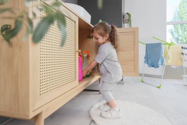 Çamaşır odasında çekmece karıştıran sevimli küçük kız. Tehlikedeki çocuk