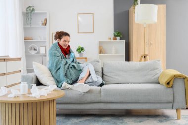 Evde termometresi ve sıcak su şişesi olan hasta genç bir kadın var.