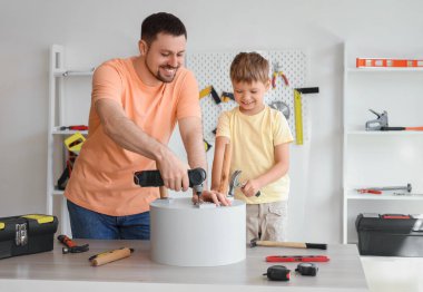 Mutlu baba ve farklı enstrümanlarla evde kahve masası kuran küçük oğlu.