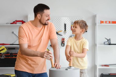 Mutlu baba ve farklı enstrümanlarla evde kahve masası kuran küçük oğlu.