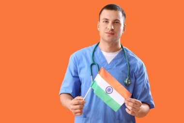 Male nurse with flag of India on orange background. National Doctor's Day celebration clipart