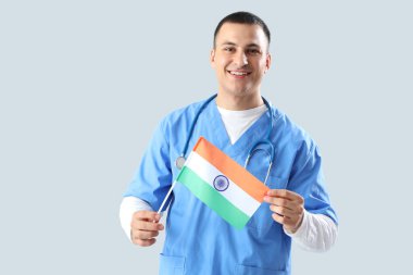 Gri arka planda Hindistan bayrağı olan erkek doktor. Ulusal Doktorların Günü kutlaması
