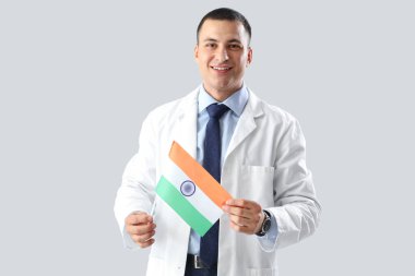 Gri arka planda Hindistan bayrağı olan erkek doktor. Ulusal Doktorların Günü kutlaması