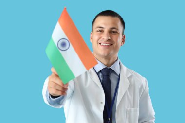 Male doctor with flag of India on blue background. National Doctor's Day celebration clipart