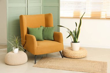 Koltuğu, çiçekleri ve katlanır perdesi olan oturma odasının içinde.