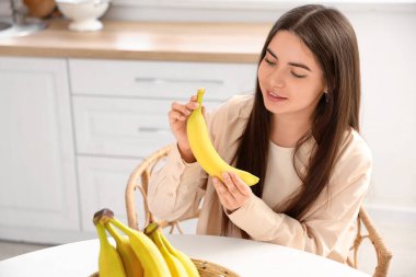 Mutfaktaki masada muzlu genç bir kadın oturuyor.