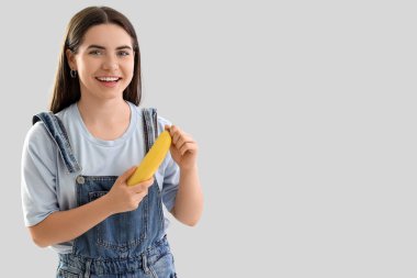 Hafif arka planda muz soyan genç kadın