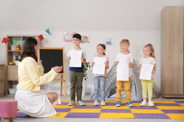 Sayıları olan küçük çocuklar ve anaokulunda anaokulu öğretmeni.