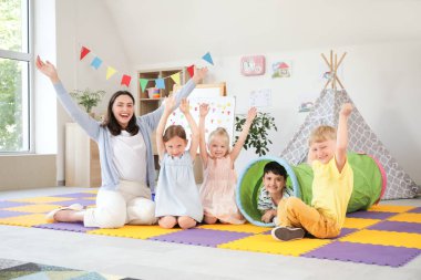 Anaokulunda oynayan, anaokulu öğretmeni olan küçük çocuklar.