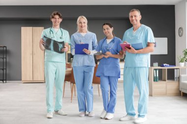 Klinikteki akciğerlerin röntgen görüntüsüne sahip bir grup doktor.