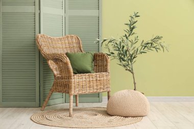 Oturma odasının içi, yeşil katlı ekran, koltuk ve puf