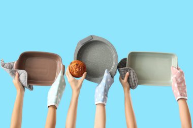 Eldivenler içinde kadın elleri ve mavi arka planda lezzetli çörekler.