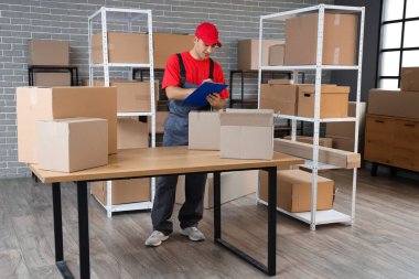 Depoda pano ve paket kutularıyla teslimatçı.