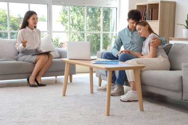 Ofiste kucaklaşan genç bir çiftle çalışan Asyalı kadın seksolog.