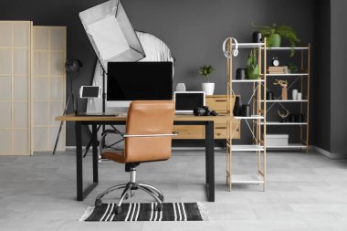 Modern fotoğraf stüdyosunda bilgisayar ve ışıklandırma ekipmanlarıyla fotoğrafçılık.