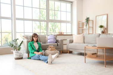 Sırt çantası, kitapları ve cep telefonu olan mutlu bir kız öğrenci.