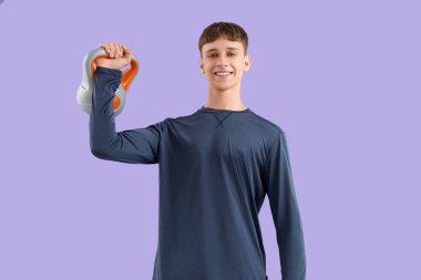 Leylak arka planında kettlebell olan sportif genç bir adam.